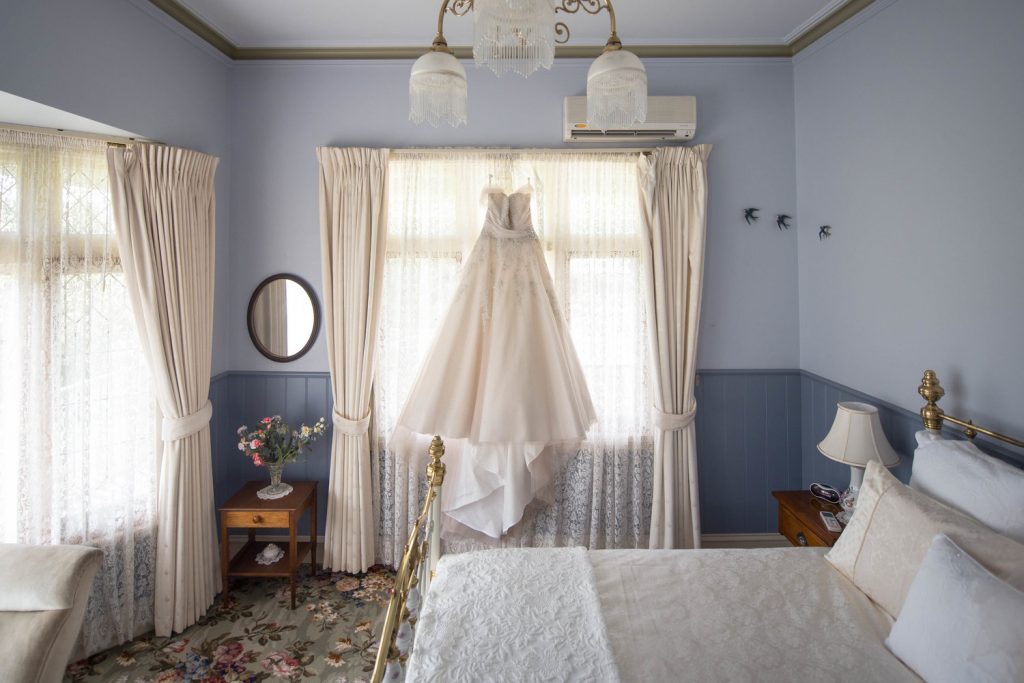 A bride gown is hanging on the window of the accommodation at Wild Cattle Creek Estate