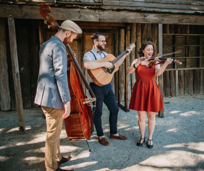 A wedding band with cello, guitar and violin at a rustic wedding venue