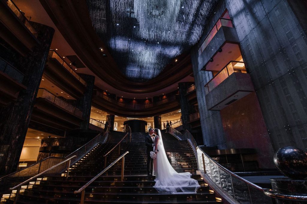 A wedding couple standing on the elegant staircase of Crown Melbourne