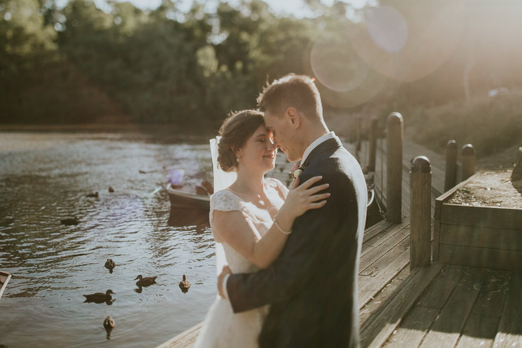 A couple near the waters and the boat of Fairfield Park Boathouse Tea Gardens