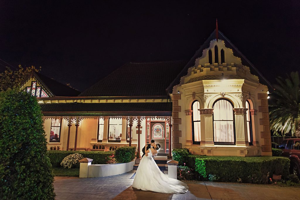 A wedding couple is dancing in front of vintage building