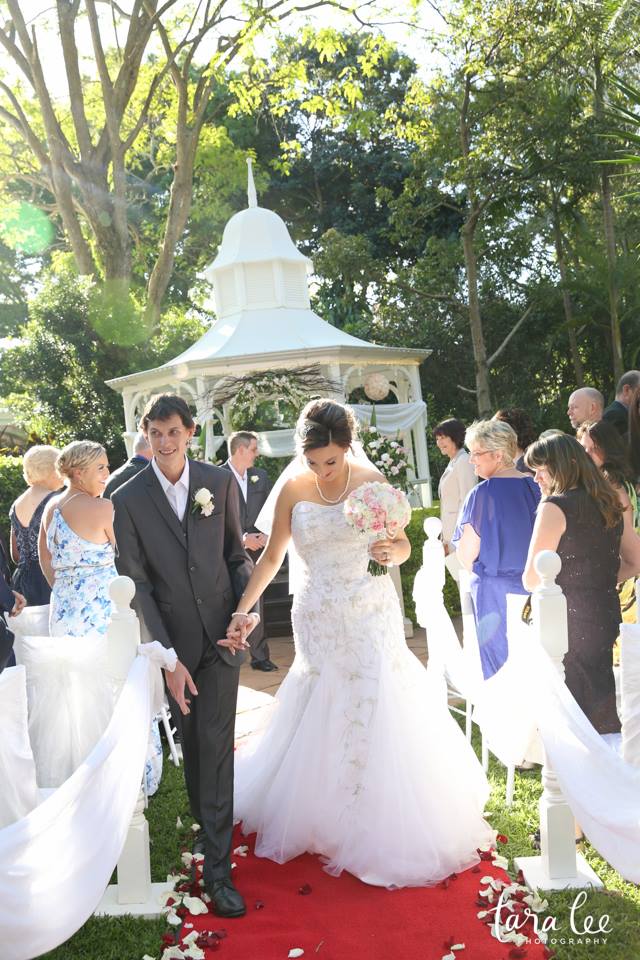 A couple is holding hands on wedding alley