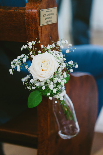 White rose and bany breath put in glass bottle and tied to wooden chair